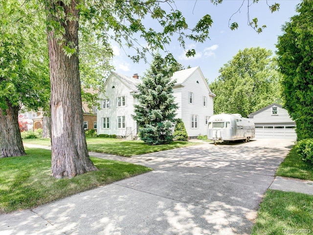2815 Military St, Fort Gratiot, MI 48060 - view of front of home featuring an outbuilding, a chimney, a front lawn, and a garage