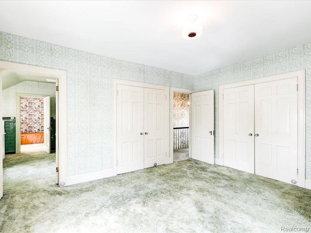 2815 Military St, Fort Gratiot, MI 48060 - unfurnished bedroom featuring wallpapered walls, carpet, and multiple closets