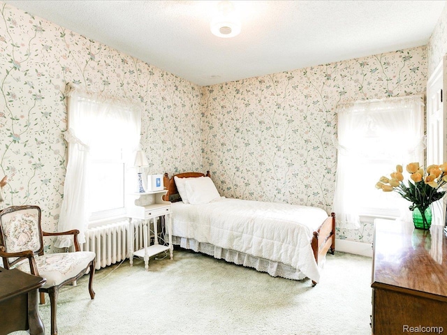 2815 Military St, Fort Gratiot, MI 48060 - carpeted bedroom featuring wallpapered walls, radiator heating unit, and a textured ceiling