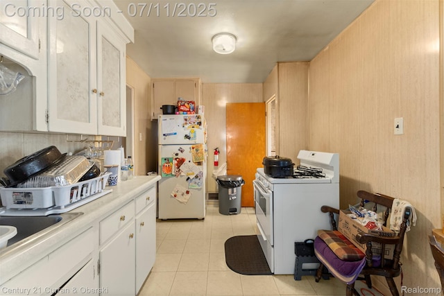 1773 Paris Ave, Lincoln Park, MI 48146 - kitchen featuring white appliances, light countertops, light tile patterned floors, and white cabinets