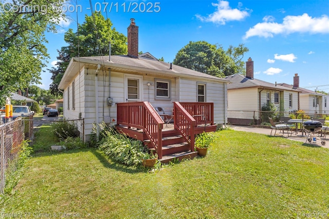 1773 Paris Ave, Lincoln Park, MI 48146 - rear view of house featuring a fenced backyard, a wooden deck, a patio, and a chimney