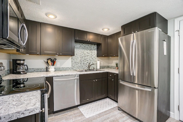 835 Farrell Ave, Kalamazoo, MI 49006 - kitchen featuring appliances with stainless steel finishes, light wood-style flooring, light countertops, a textured ceiling, and dark brown cabinetry