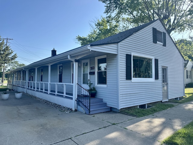 1805 Lakeshore Dr, Saint Joseph, MI 49085 - view of front of house with covered porch and a chimney