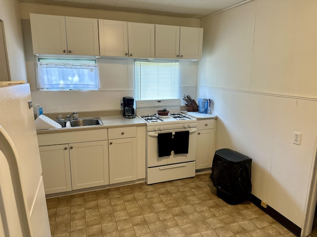 1805 Lakeshore Dr, Saint Joseph, MI 49085 - kitchen with white range with gas stovetop, fridge, white cabinets, and light countertops
