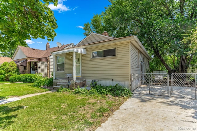1085 Pennsylvania Ave, Lincoln Park, MI 48146 - view of front facade with a gate, a chimney, and driveway