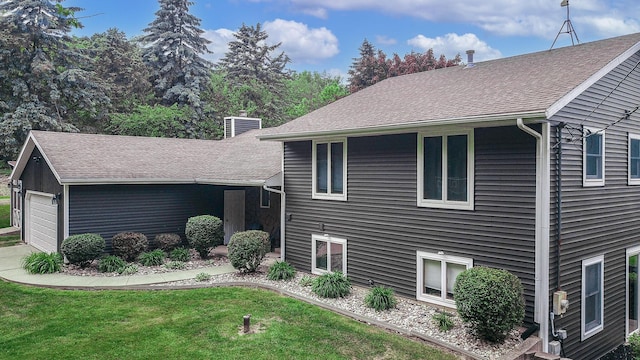7640 W H Ave, Kalamazoo, MI 49009 - view of front facade with a front lawn, a chimney, and an attached garage