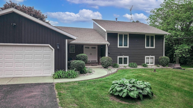 7640 W H Ave, Kalamazoo, MI 49009 - tri-level home featuring an attached garage, a front lawn, a shingled roof, and asphalt driveway