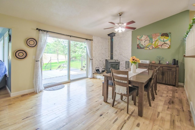 7640 W H Ave, Kalamazoo, MI 49009 - dining space with a wood stove, ceiling fan, light wood-style flooring, and lofted ceiling