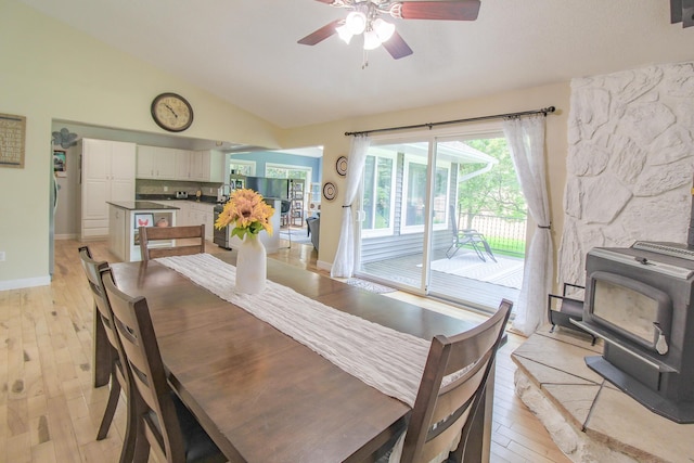 7640 W H Ave, Kalamazoo, MI 49009 - dining area with a wood stove, ceiling fan, vaulted ceiling, and light wood-style floors