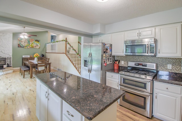 7640 W H Ave, Kalamazoo, MI 49009 - kitchen featuring stainless steel appliances, light wood-style flooring, white cabinetry, and a textured ceiling
