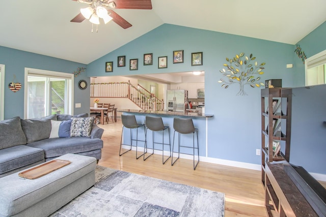 7640 W H Ave, Kalamazoo, MI 49009 - living area with ceiling fan, light wood finished floors, stairway, and high vaulted ceiling
