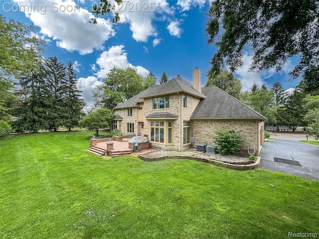 4532 Franklin Mill Rd, Southfield, MI 48301 - back of house featuring a lawn, brick siding, a chimney, a patio, and roof with shingles