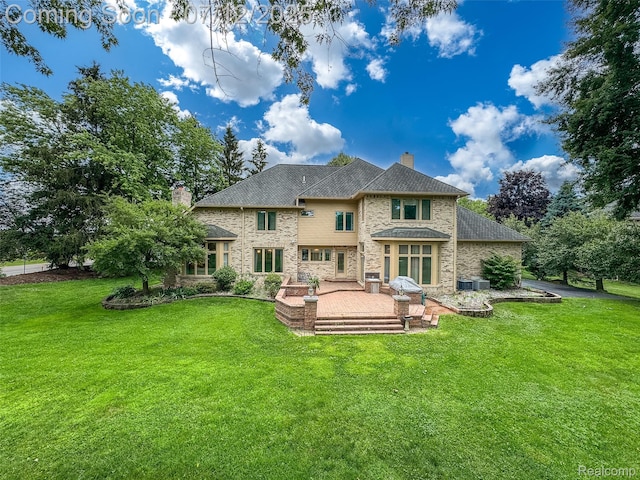 4532 Franklin Mill Rd, Southfield, MI 48301 - rear view of house featuring a chimney, a patio, a lawn, and stone siding