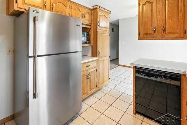 2295 Plainview Dr, Saginaw, MI 48603 - kitchen featuring freestanding refrigerator, black dishwasher, light tile patterned floors, light countertops, and brown cabinetry