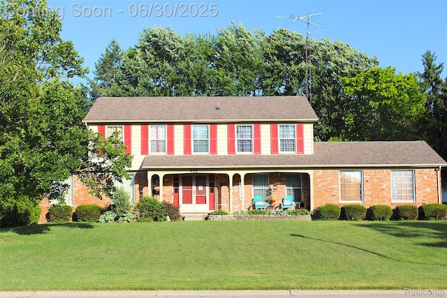 486 Charing Cross Dr, Grand Blanc, MI 48439 - colonial inspired home featuring brick siding, covered porch, a front lawn, and roof with shingles