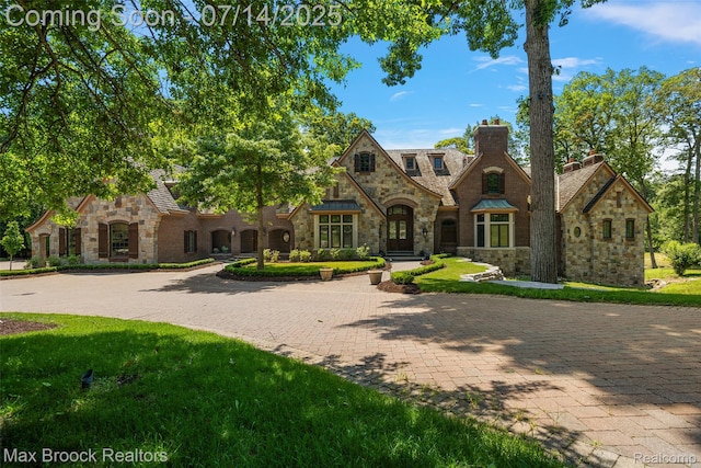 7420 Inner Circle Dr, Bloomfield Hills, MI 48301 - tudor home with stone siding, a chimney, a front lawn, and driveway
