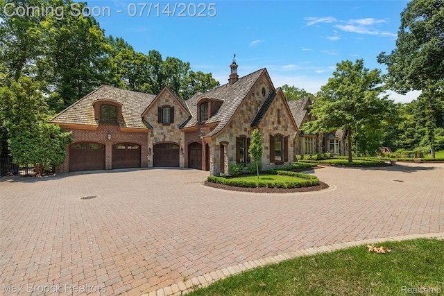 7420 Inner Circle Dr, Bloomfield Hills, MI 48301 - view of front of property with stone siding, curved driveway, and a high end roof
