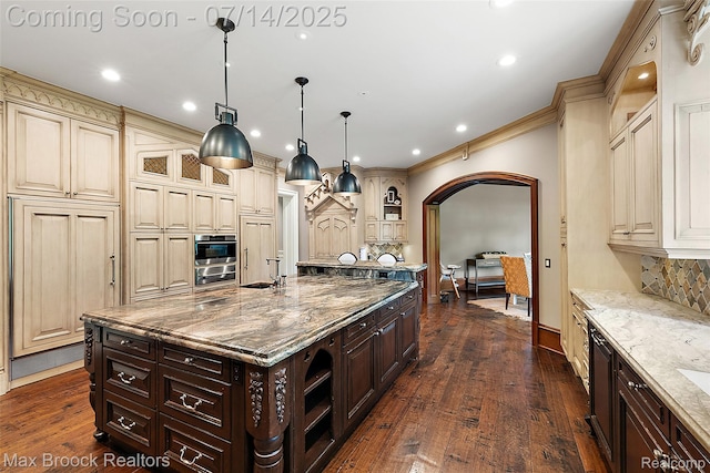 7420 Inner Circle Dr, Bloomfield Hills, MI 48301 - kitchen with cream cabinets, arched walkways, tasteful backsplash, dark wood-type flooring, and recessed lighting