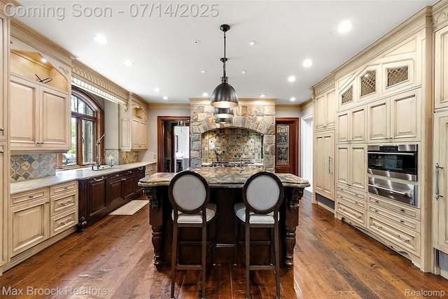 7420 Inner Circle Dr, Bloomfield Hills, MI 48301 - kitchen with a warming drawer, oven, cream cabinets, crown molding, and dark wood finished floors