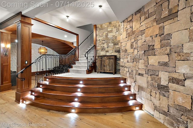 7420 Inner Circle Dr, Bloomfield Hills, MI 48301 - stairs with wood-type flooring, decorative columns, and a chandelier