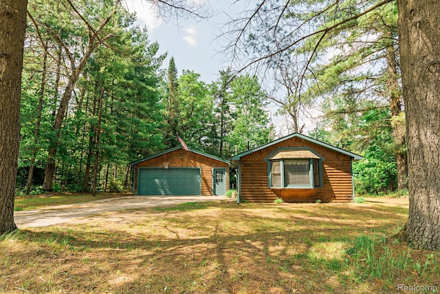 4176 Kings Corner Rd, Glennie, MI 48737 - rustic home featuring a detached garage, faux log siding, and a front lawn