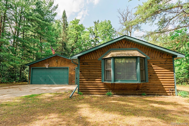4176 Kings Corner Rd, Glennie, MI 48737 - rustic home featuring a garage, driveway, and faux log siding