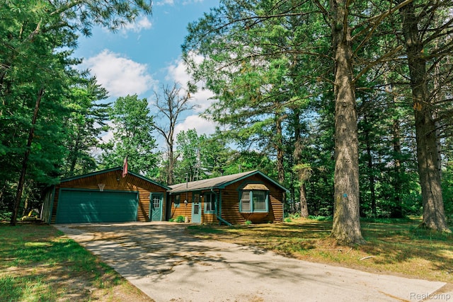 4176 Kings Corner Rd, Glennie, MI 48737 - view of front facade with driveway, an attached garage, and faux log siding