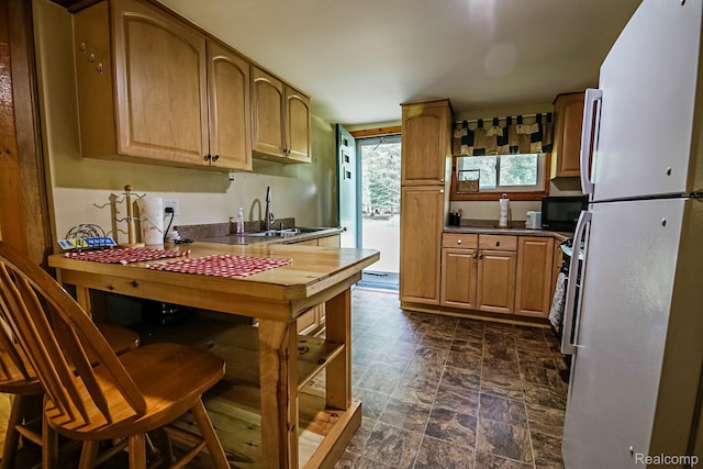 4176 Kings Corner Rd, Glennie, MI 48737 - kitchen with freestanding refrigerator, stone finish flooring, and dark countertops