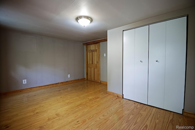 4176 Kings Corner Rd, Glennie, MI 48737 - unfurnished bedroom with wood finished floors and a closet