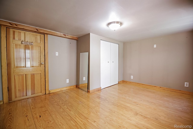 4176 Kings Corner Rd, Glennie, MI 48737 - unfurnished bedroom featuring light wood-style flooring and a closet