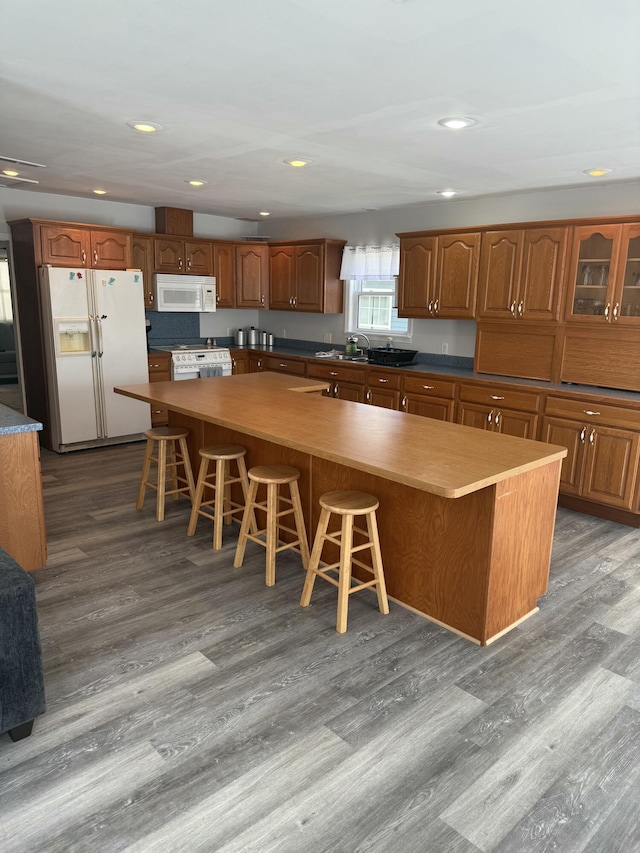 9500 Humphrey Rd, Reading, MI 49274 - kitchen with white appliances, wood finished floors, a spacious island, brown cabinets, and recessed lighting