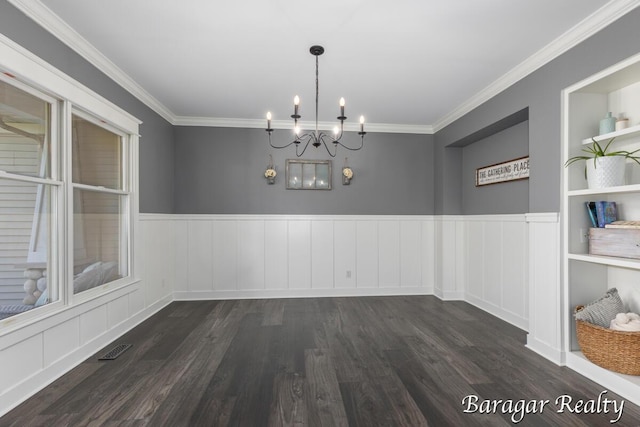 8790 Laurel Ridge Dr SE, Alto, MI 49302 - unfurnished dining area featuring a chandelier, dark wood-style flooring, crown molding, wainscoting, and a decorative wall