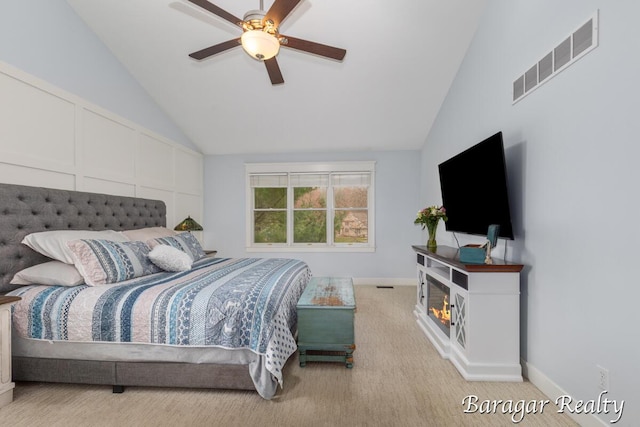 8790 Laurel Ridge Dr SE, Alto, MI 49302 - bedroom featuring lofted ceiling, carpet flooring, a warm lit fireplace, and a ceiling fan