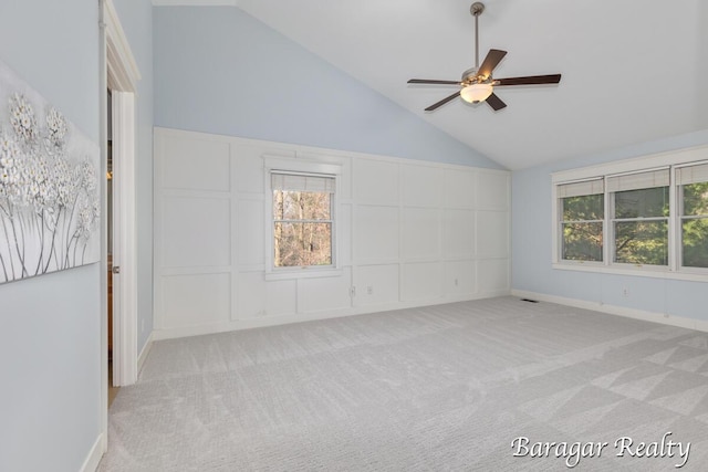 8790 Laurel Ridge Dr SE, Alto, MI 49302 - empty room with light carpet, ceiling fan, high vaulted ceiling, and a decorative wall