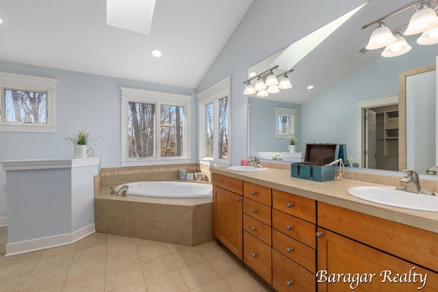 8790 Laurel Ridge Dr SE, Alto, MI 49302 - bathroom featuring a skylight, lofted ceiling, double vanity, a bath, and tile patterned flooring