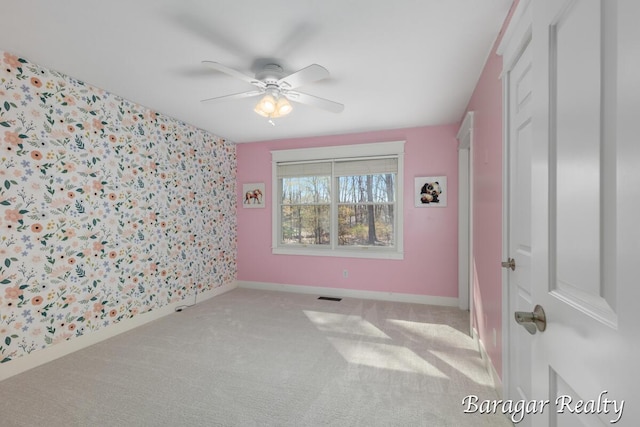 8790 Laurel Ridge Dr SE, Alto, MI 49302 - carpeted empty room with ceiling fan, an accent wall, and wallpapered walls