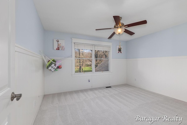 8790 Laurel Ridge Dr SE, Alto, MI 49302 - carpeted spare room featuring a wainscoted wall and a ceiling fan