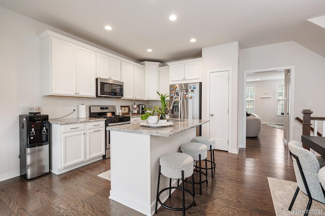 2855 Hardwick Rd, Ann Arbor, MI 48105 - kitchen with stainless steel appliances, dark wood-style floors, white cabinets, a breakfast bar area, and recessed lighting