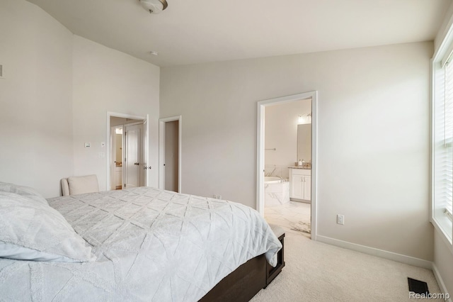 2855 Hardwick Rd, Ann Arbor, MI 48105 - bedroom with vaulted ceiling, light colored carpet, connected bathroom, and multiple windows