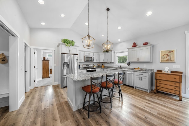14170 Spring Valley Ct, Niles, MI 49120 - kitchen featuring stainless steel appliances, a kitchen island, a chandelier, a breakfast bar area, and light wood-style flooring