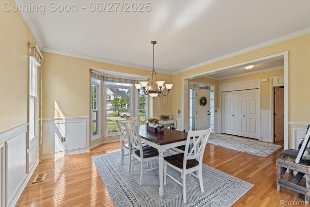 6060 Balmoral Way, Commerce Twp, MI 48382 - dining room featuring a chandelier, ornamental molding, light wood-style flooring, wainscoting, and a decorative wall