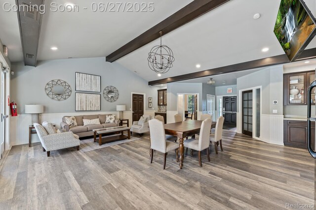 6060 Balmoral Way, Commerce Twp, MI 48382 - dining space featuring wood finished floors, a wainscoted wall, a chandelier, healthy amount of natural light, and a decorative wall