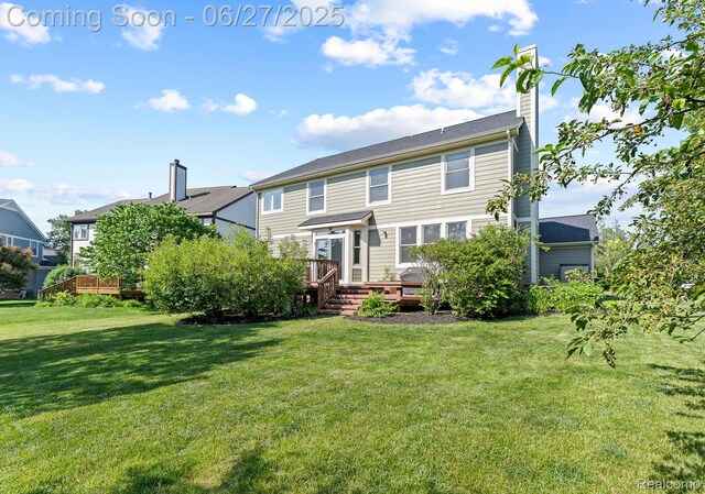 6060 Balmoral Way, Commerce Twp, MI 48382 - rear view of house with a wooden deck, a chimney, and a yard