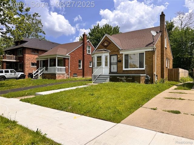 9646 Ward St, Dearborn, MI 48227 - bungalow-style house featuring brick siding, a chimney, a front yard, and roof with shingles
