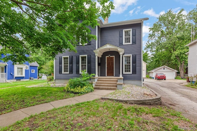 830 College Ave, Adrian, MI 49221 - view of front of home featuring an outdoor structure, a garage, a front yard, and a chimney