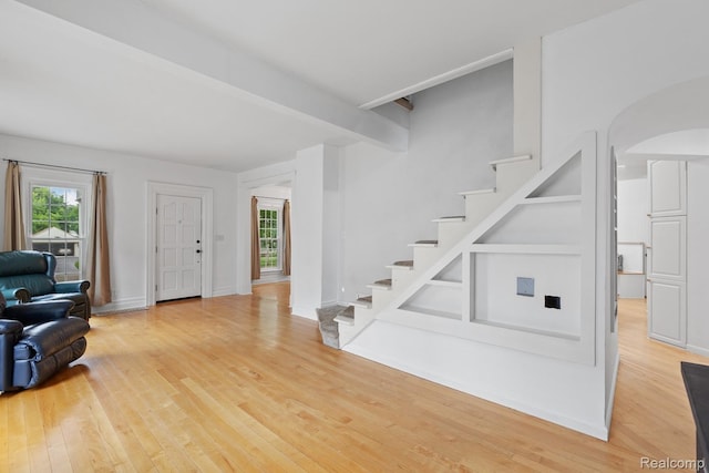 830 College Ave, Adrian, MI 49221 - foyer with wood finished floors, stairs, beam ceiling, and arched walkways