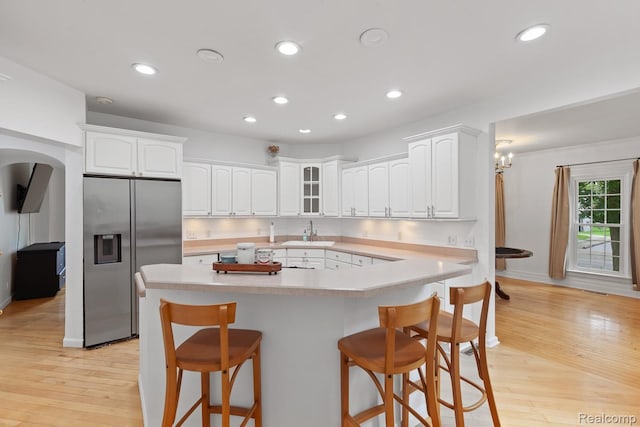 830 College Ave, Adrian, MI 49221 - kitchen featuring stainless steel refrigerator with ice dispenser, a breakfast bar area, white cabinetry, recessed lighting, and light countertops