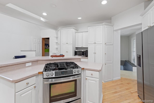 830 College Ave, Adrian, MI 49221 - kitchen featuring stainless steel appliances, light countertops, light wood-style flooring, white cabinets, and recessed lighting