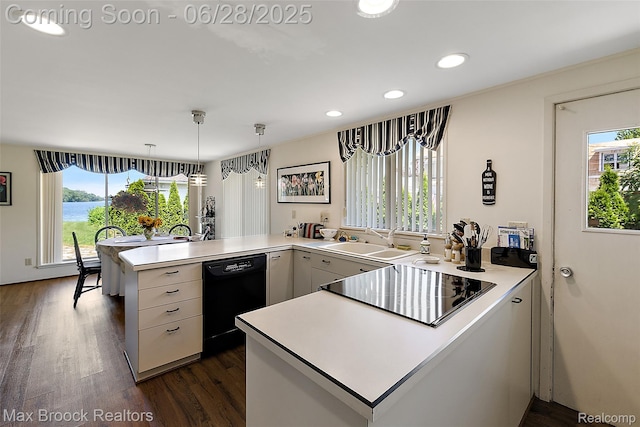 4848 Willow Ln, Orchard Lake, MI 48324 - kitchen with a peninsula, black appliances, light countertops, dark wood-type flooring, and recessed lighting