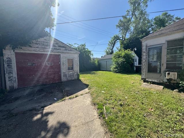 18460 Ferguson St, Detroit, MI 48235 - view of grassy yard featuring driveway and an outdoor structure